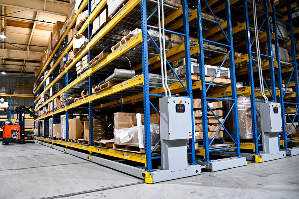 Mobile pallet racking with powered mobile bases on floor rails and single working aisle